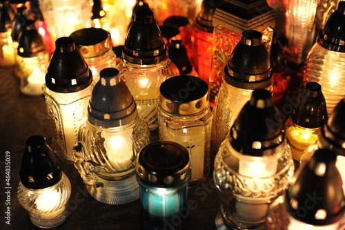 Candle lights on graves and tombstones in cemetery at night in Poland on All Saints’ Day or All Souls’ Day or Halloween or Zaduszki or Day of the Dead photo