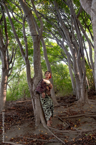 Balinese girl posing in nature and in a forest on Candidasa s offshore islands in Bali  dressed in a traditional costume. 
