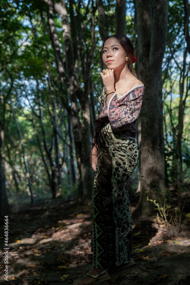 Balinese girl posing in nature and in a forest on Candidasa's offshore islands in Bali, dressed in a traditional costume. Balinese girl posing in nature and in a forest on Candidasa's offshore islands in Bali, dressed in a traditional costume.