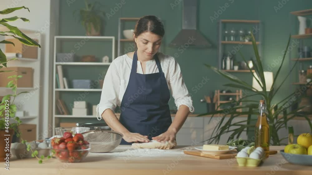 Professional Chef Sprinkles Flour and Kneads Dough on a Wooden Table in a Modern Home Kitchen. The Process of Making a Beautiful Dough. Homemade Cakes For a Pastry Shop. Startup. Professional Chef Sprinkles Flour and Kneads Dough on a Wooden Table in a Modern Home Kitchen. The Process of Making a Beautiful Dough. Homemade Cakes For a Pastry Shop. Startup.