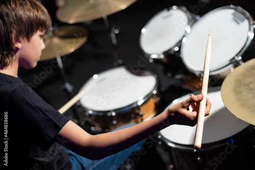 A boy plays drums in a recording studio