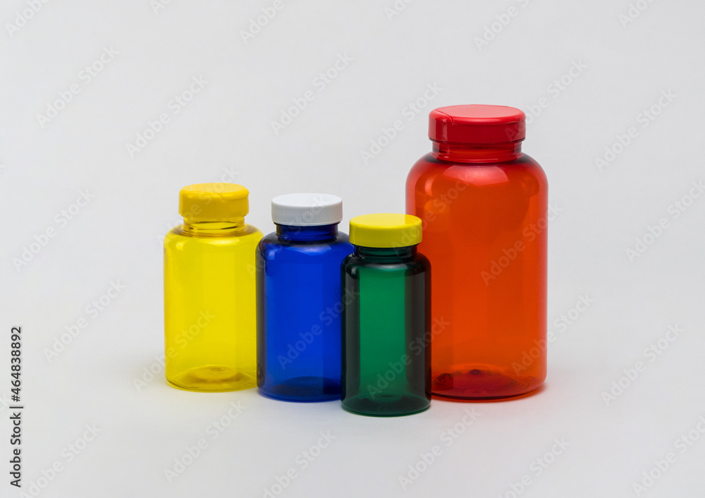 Multi colored transparent plastic pill jars on a white background. Isolated Multi colored transparent plastic pill jars on a white background. Isolated