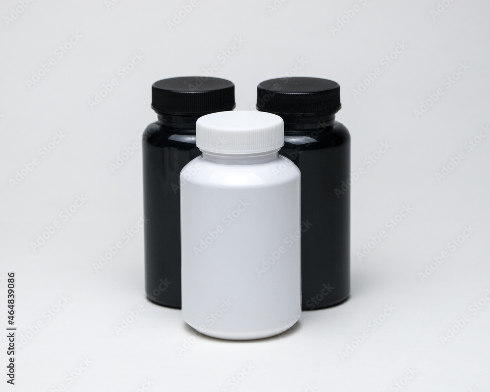 White and black plastic pill jars on a white background. Isolated White and black plastic pill jars on a white background. Isolated