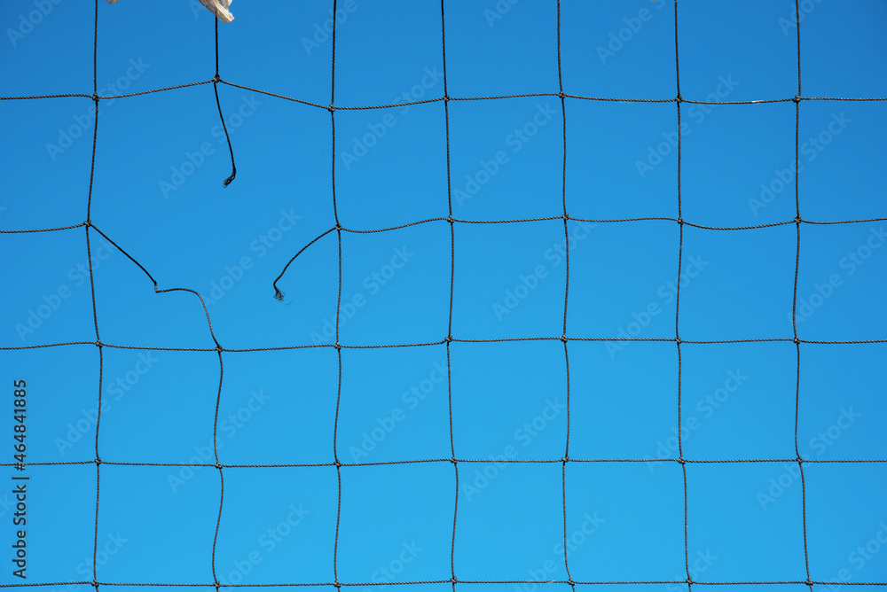 Torn volleyball net on sky background (failure, loss, breakdown - concept)
