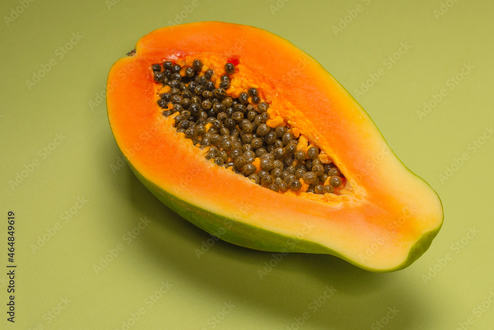 Papaya fruit on a green background. Half papaya. Papaya fruit on a green background. Half papaya.