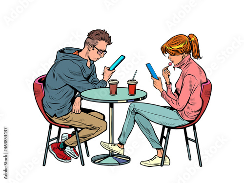 a couple on a date in a restaurant are looking at smartphones and not talking, loneliness and new technologies