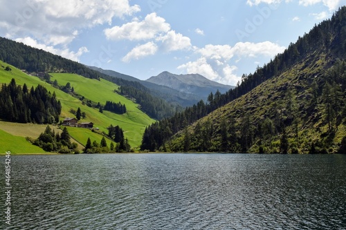 Lago di Valdurna in AltoAdige cielo serene e riflessi sulla superficie, chiesa tipica con campanile appuntito photo