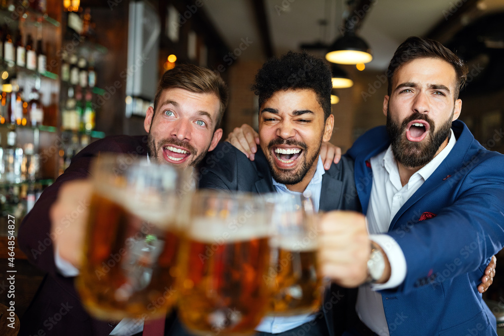 Business men in pub cheering for a sporting event Business men in pub cheering for a sporting event