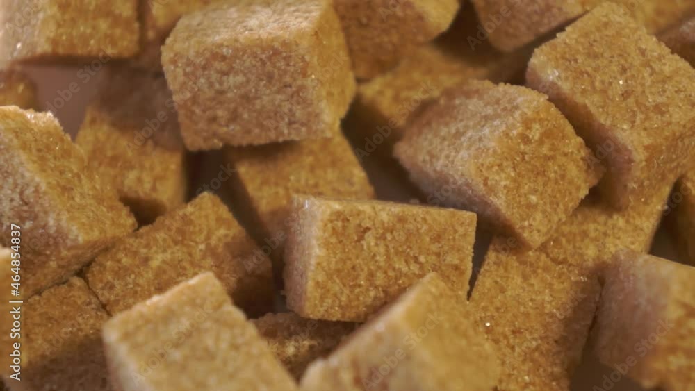 cane lump sugar. rotating brown sugar cubes. Demerara golden brown sugar. close up cane lump sugar. rotating brown sugar cubes. Demerara golden brown sugar. close up