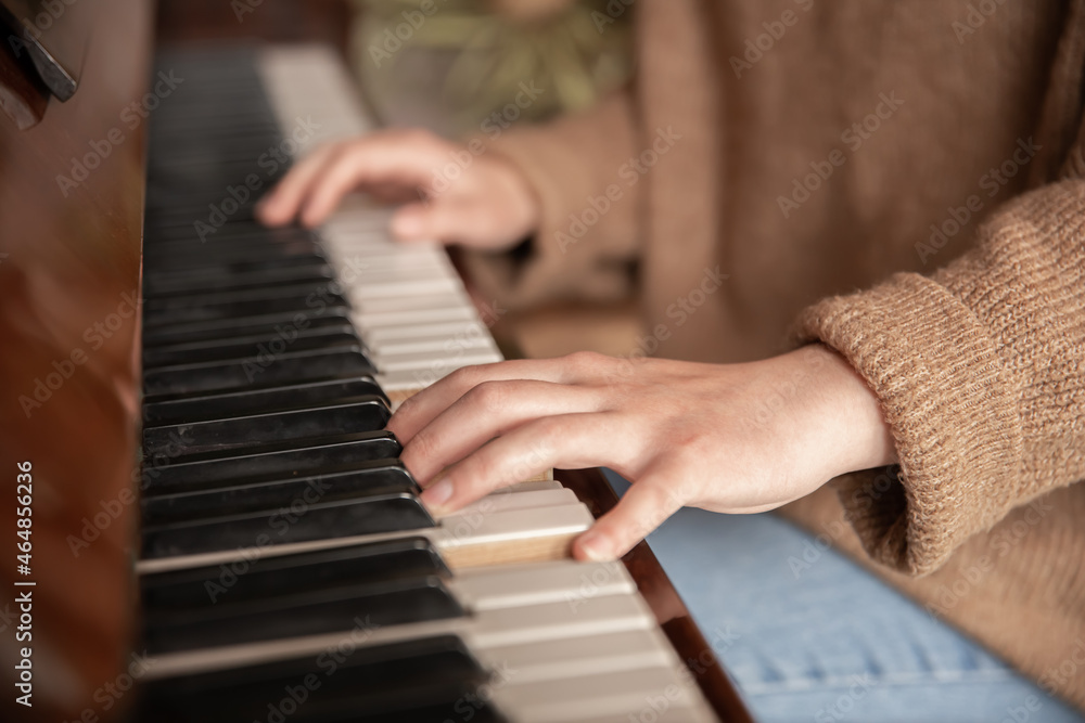 Close-up of female hands playing the piano.