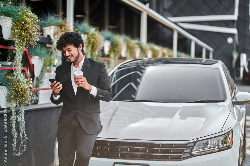 curly-haired businessman from India drinks coffee