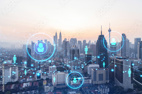 Photography Hologram of social media icons over sunset panoramic cityscape of Kuala Lumpur, Malaysia, Asia