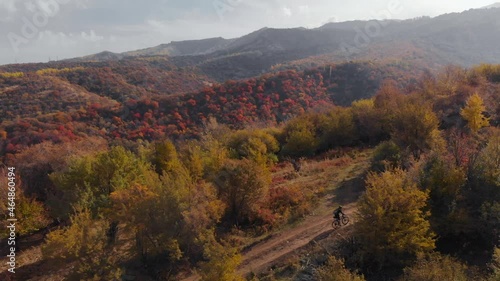 Aerial view of cyclist in the mountain landscape with autumn forest photo