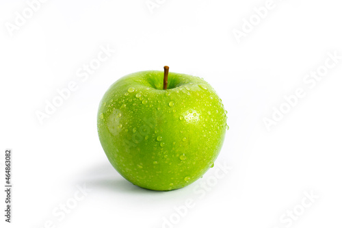 Juicy green apple with water drops on an isolated background.