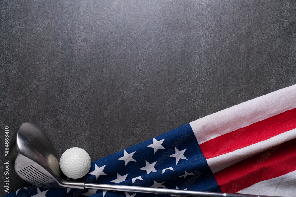 Golf ball and golf club with flag of USA on black table background
