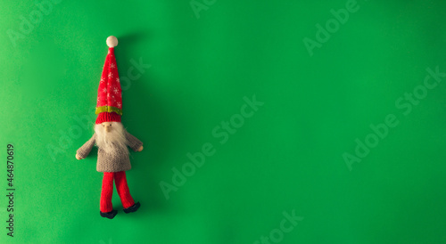 Christmas elf on green background. Copy space. Selective focus.