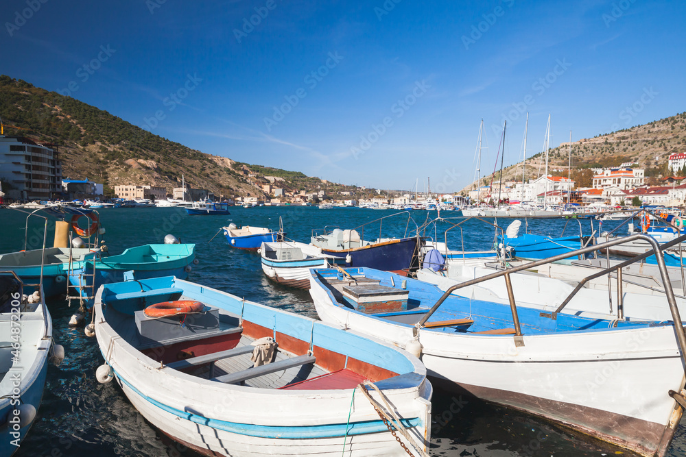 White wooden boats are moored in marina. Balaklava