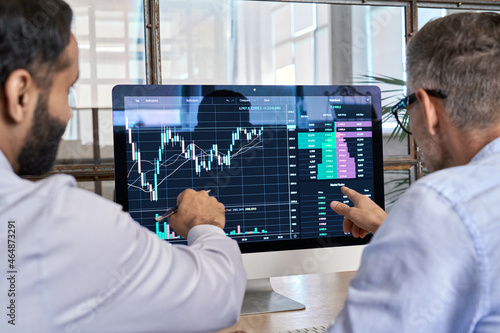 Obraz na plátně Two traders brokers stock exchange market investors discussing crypto trading charts growth using pc computer pointing at screen analyzing financial risks, investment profit forecast