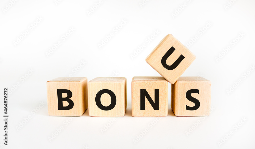 Bonus symbol. The concept word 'bonus' on wooden cubes. Beautiful white table, white background. Business and bonus concept. Copy space. Bonus symbol. The concept word 'bonus' on wooden cubes. Beautiful white table, white background. Business and bonus concept. Copy space.
