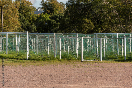 Many soccer goals placed on a field.