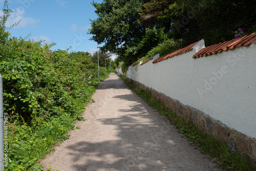White brick wall by a narrow uphill path.