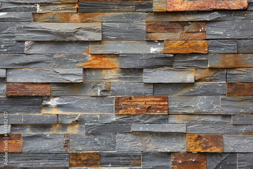 A view of a wall facade of horizontal stacked gray stones, as a background.
