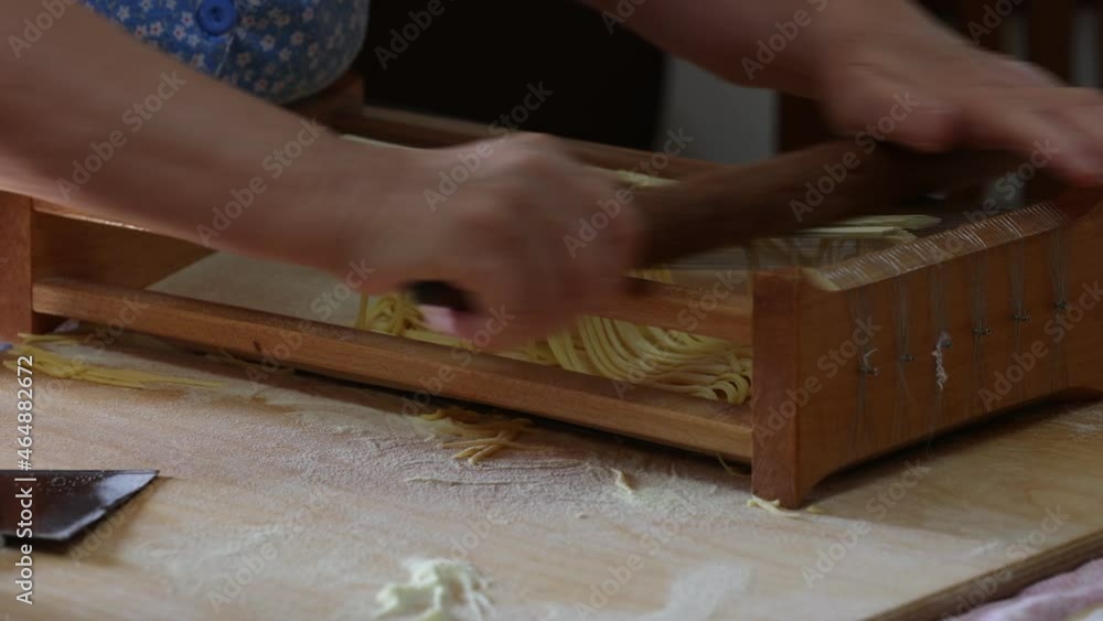 Elderly woman cutting pasta alla chitarra, typical dish of the Abruzzo region. Elderly woman cutting pasta alla chitarra, typical dish of the Abruzzo region.