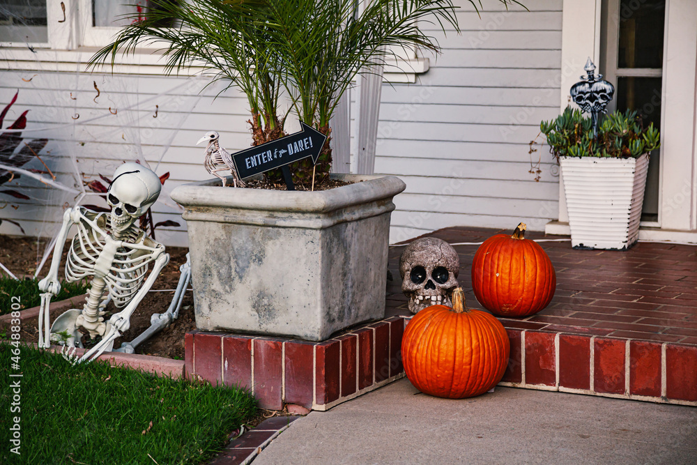 Naklejka premium The front lawn is decorated with skeletons, graves and ghosts for the Halloween celebration. Halloween background