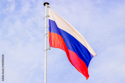 National flag of Russia on a pole against against the sky