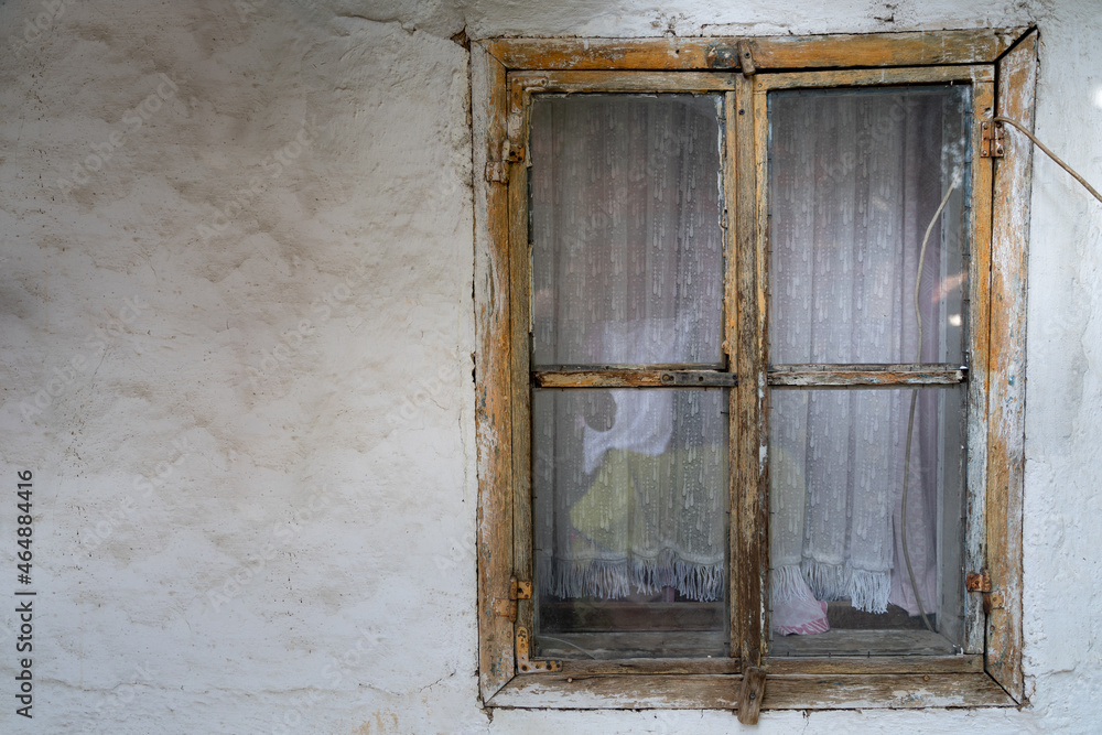 Old wooden window on an old white house with copy space on the left side 
