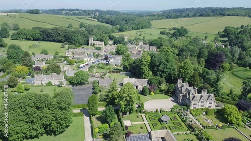 Aerial showing Lord of the manor, green fields, hills and gardens of English countryside between upper and lower slaughter in Cheltenham, Cotswold England, UK