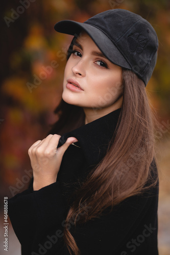 Autumn portrait of an attractive girl in a baseball cap. Autumn shades. Stylish girl
