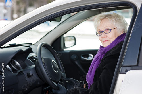Stylish senior woman sitting in her car. Ready to start driving. © ekim