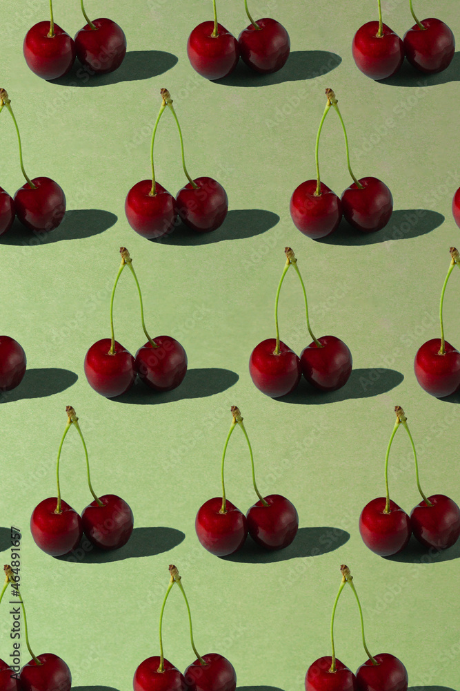 Red cherry pattern on the green backdrop Red cherry pattern on the green backdrop