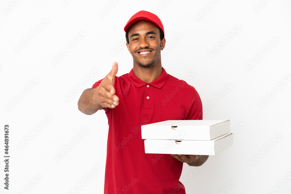 African American pizza delivery man picking up pizza boxes over isolated white wall shaking hands for closing a good deal African American pizza delivery man picking up pizza boxes over isolated white wall shaking hands for closing a good deal