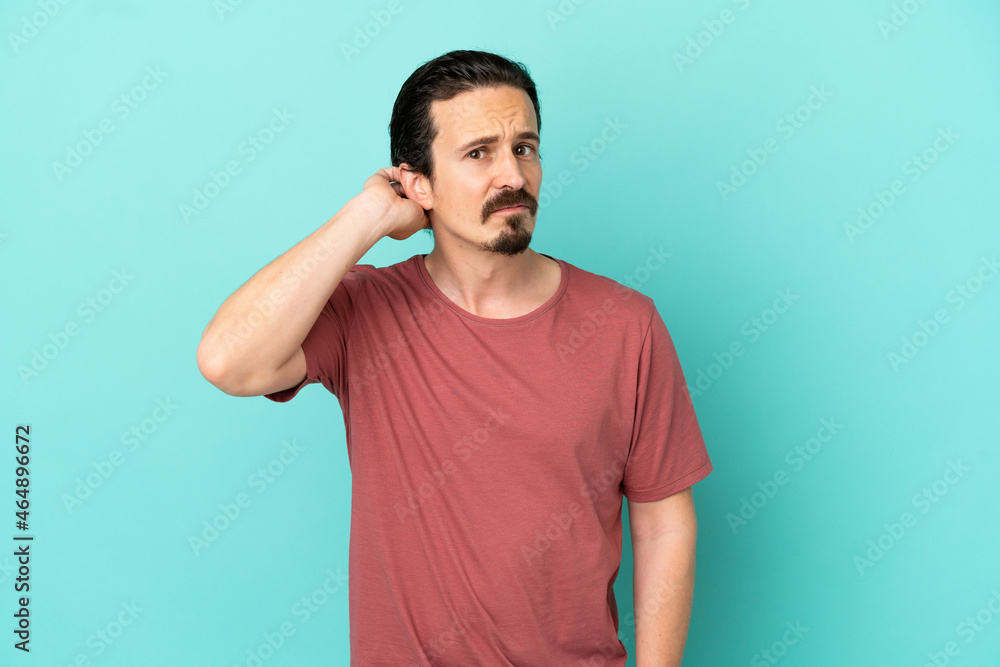 Young caucasian man isolated on blue background having doubts Young caucasian man isolated on blue background having doubts