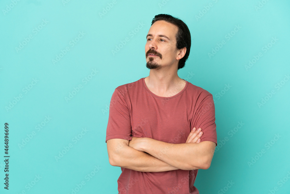 Young caucasian man isolated on blue background looking to the side Young caucasian man isolated on blue background looking to the side