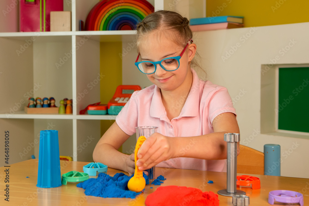 A girl with Down syndrome plays with kinetic sand A girl with Down syndrome plays with kinetic sand