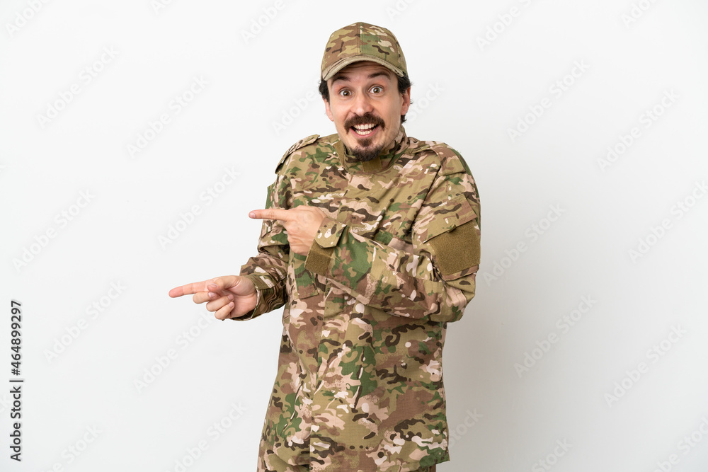 Soldier man isolated on white background surprised and pointing side Soldier man isolated on white background surprised and pointing side