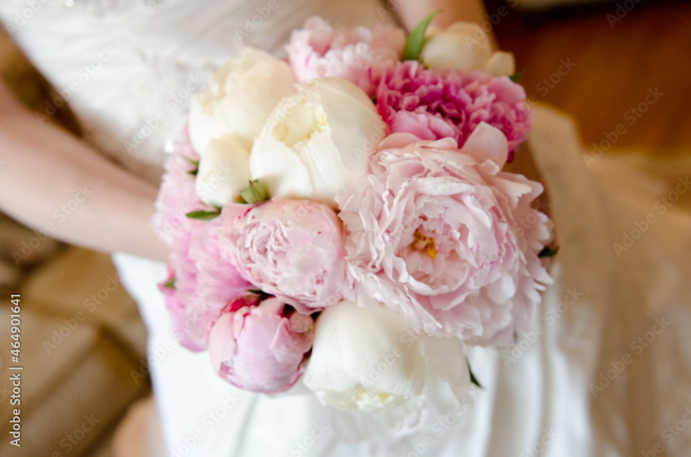 Wedding beautiful pink piwon bouquet in bride hands some blur background