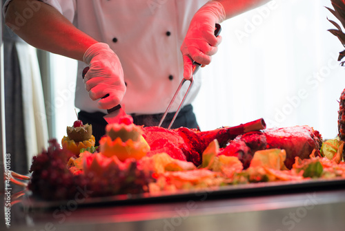 The cook's hands are butchering the food for serving. Blur food
