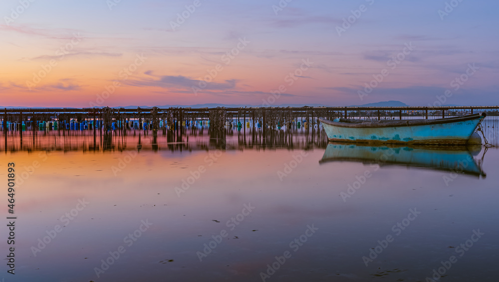 Vue d'un coucher de soleil sur les parcs à moules d'un étang de la Camargue, réserve naturelle protégée	
