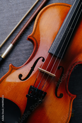 Close up image of a new violin on a grey textile surface