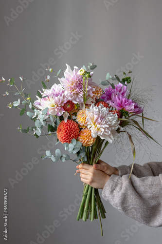Canvas Print A woman is holding a festive bouquet with chrysathemum flowers in her hands