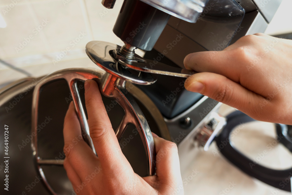 The hands changes the tool to the food processor. Change of a nozzle of the Kitchen Machine. kitchen unit. close-up The hands changes the tool to the food processor. Change of a nozzle of the Kitchen Machine. kitchen unit. close-up