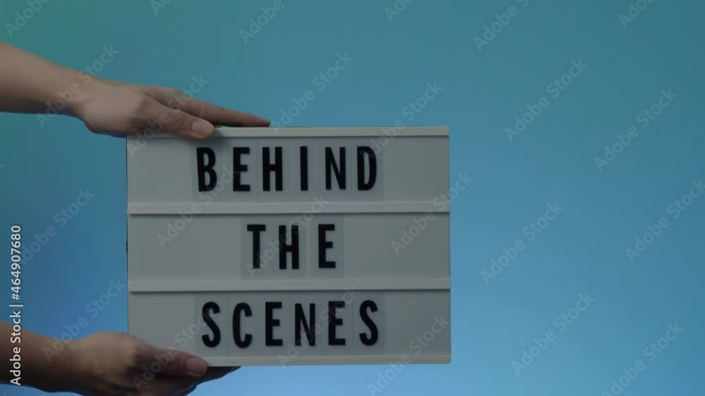 Behind the scene light box. Black text on white lightbox of word Behind the scenes. prop include megaphone movie clapperboard and director chair in studio. footage for video production making of. Behind the scene light box. Black text on white lightbox of word Behind the scenes. prop include megaphone movie clapperboard and director chair in studio. footage for video production making of.