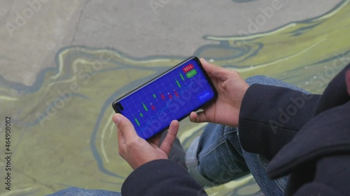 Young female analyzes a cryptocurrency stock market chart on her mobile phone