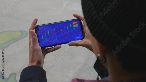 Young female analyzes a cryptocurrency stock market chart on her mobile phone