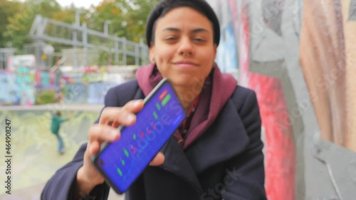 Young female analyzes a cryptocurrency stock market chart on her mobile phone