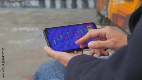 Young female analyzes a cryptocurrency stock market chart on her mobile phone